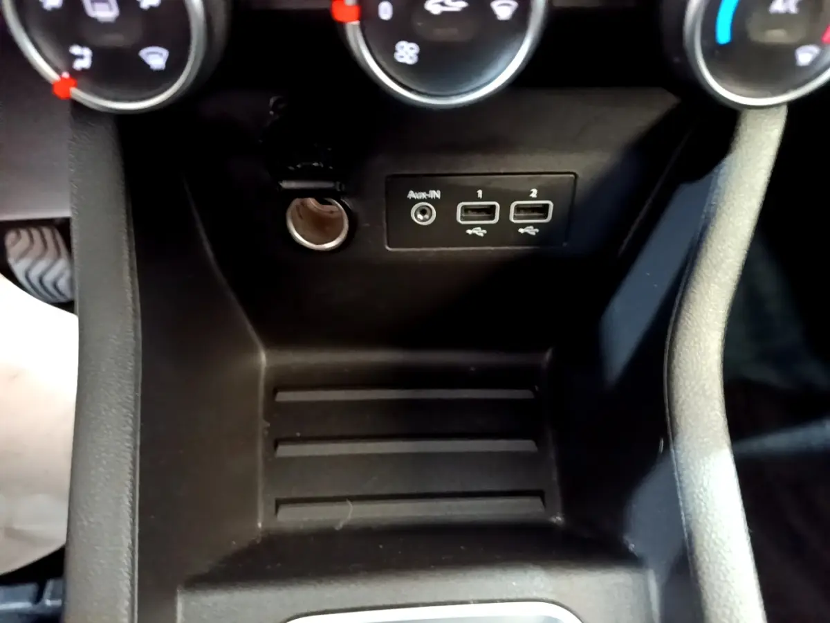 Gros plan sur la console centrale noire de la Renault Clio Business Blue dCi 115, avec prises USB et prise auxiliaire.