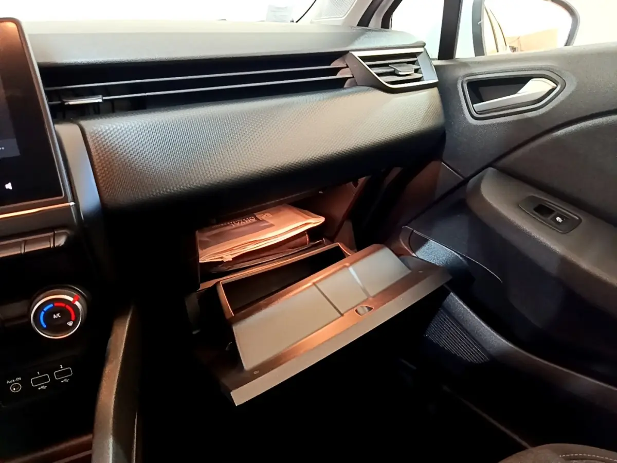 Vue intérieure côté passager de la Renault Clio Business Blue dCi 115 2020, boîte à gants ouverte et tableau de bord noir.