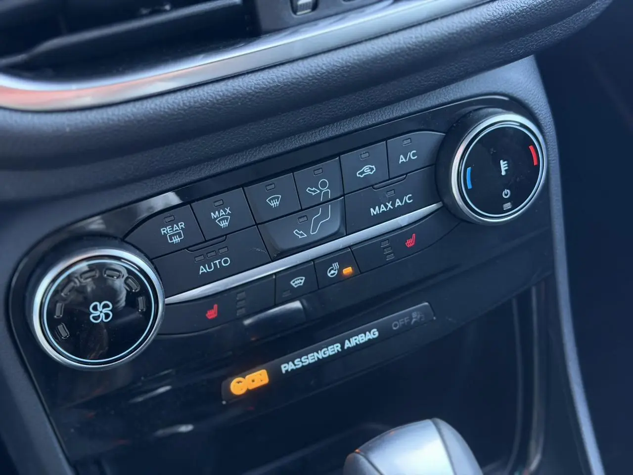 Détail du tableau de bord noir du Ford Puma 2023 montrant les commandes de climatisation automatique et sièges chauffants.