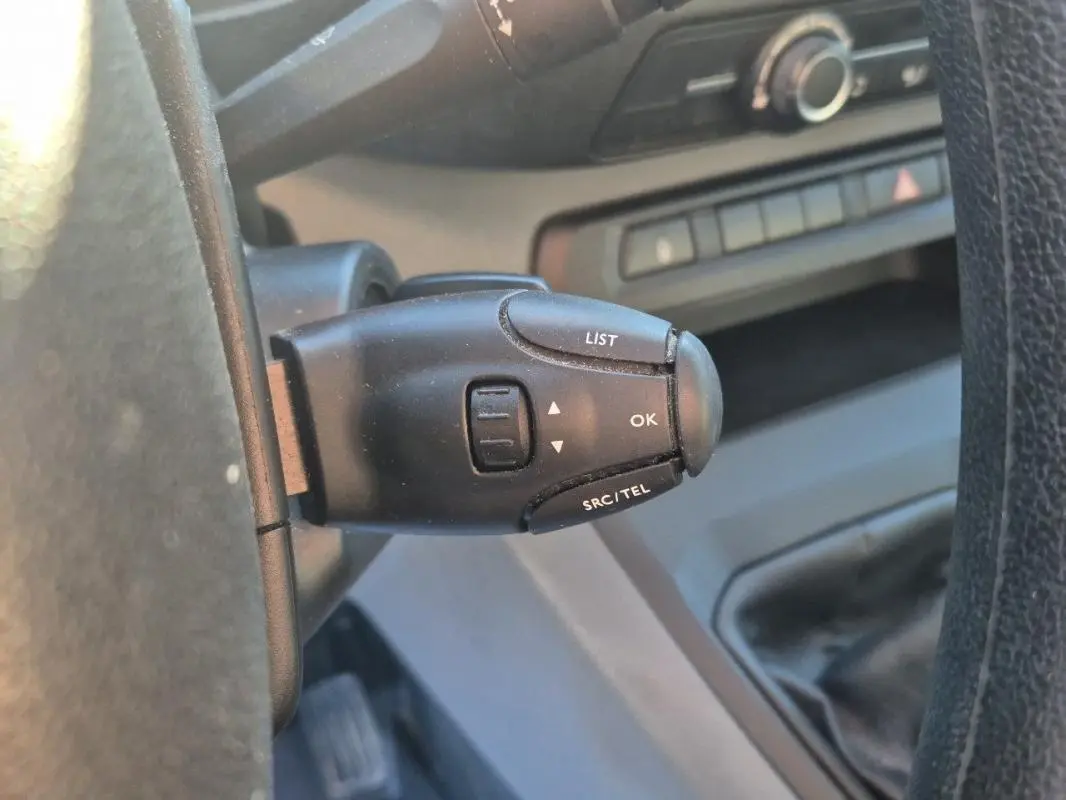 Gros plan sur la commande au volant du Citroën Jumpy blanc, version fourgon L1H1, montrant les boutons LIST, OK et SRC/TEL.