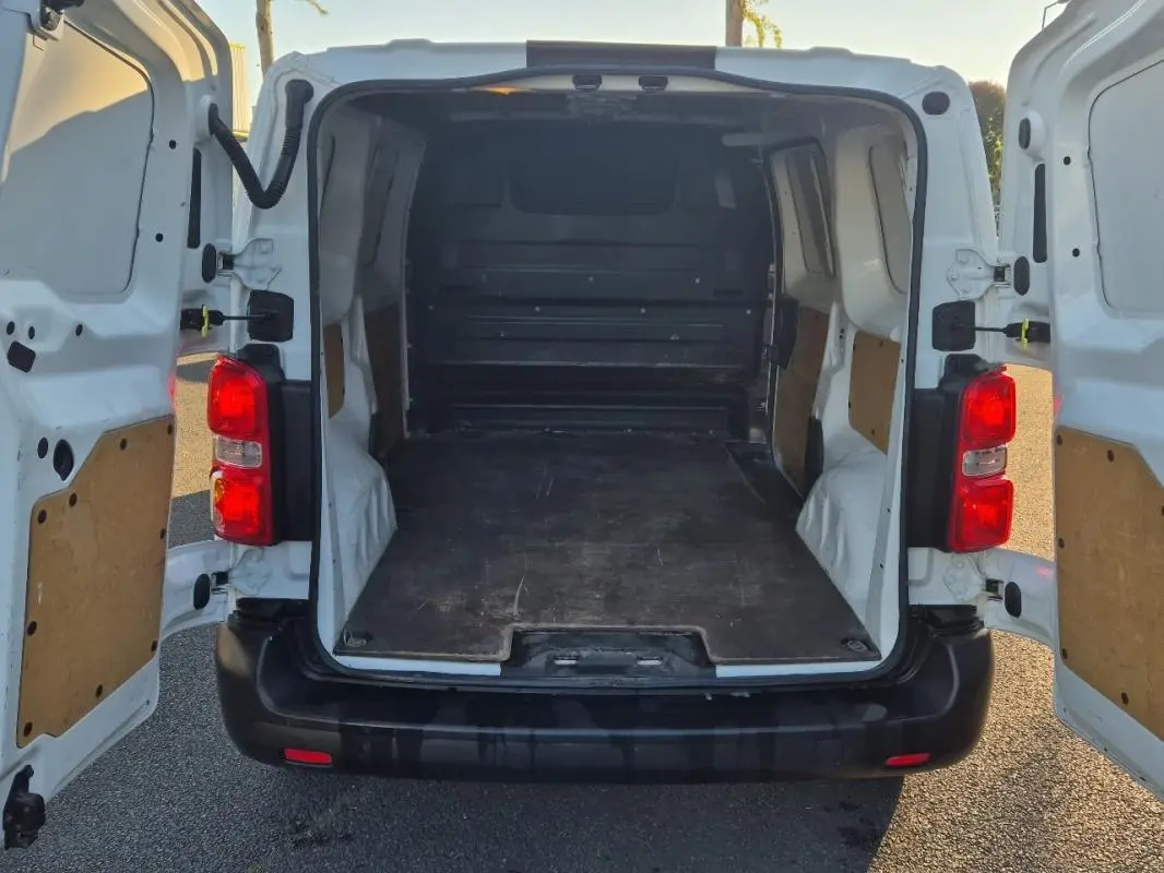 Vue arrière ouverte du fourgon blanc Citroën Jumpy L1H1 2019, montrant l’espace de chargement vide et les portes battantes.