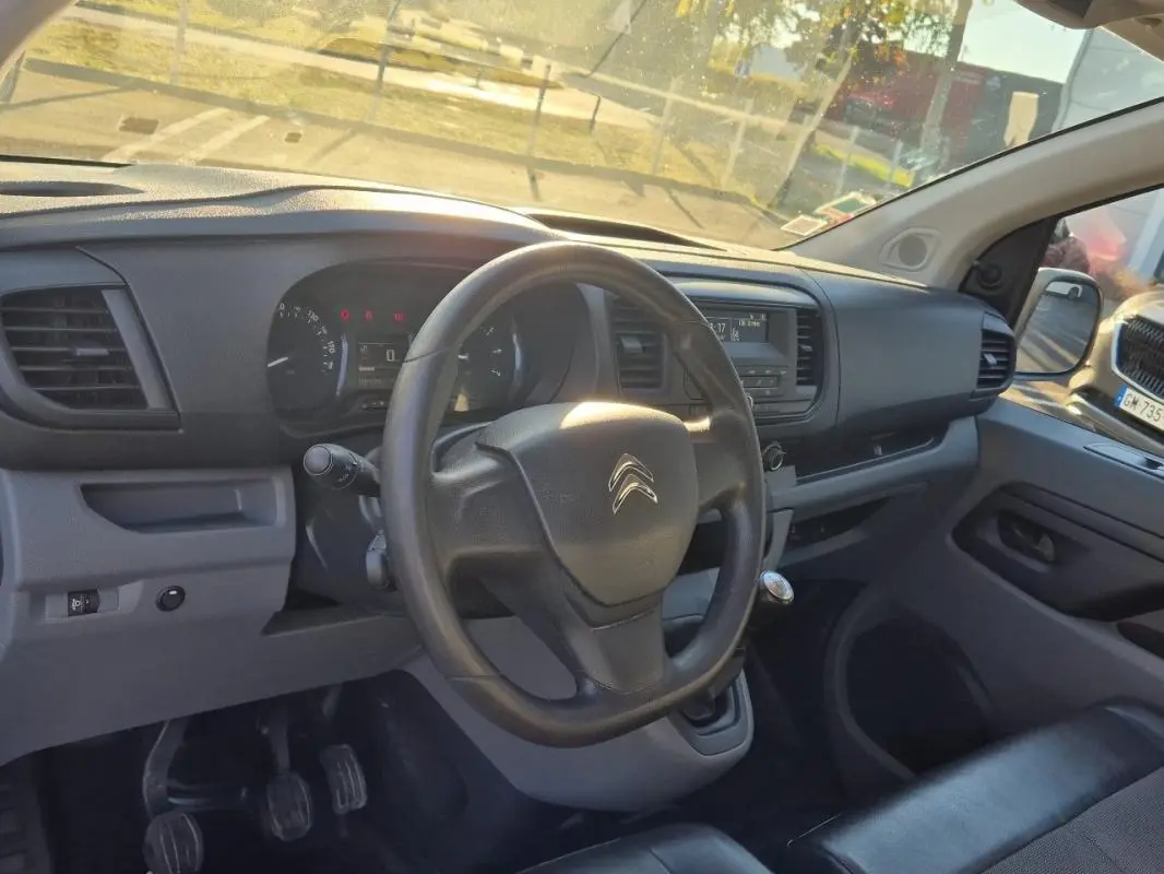 Intérieur du Citroën Jumpy 2019 vu côté conducteur, tableau de bord noir avec volant et levier de vitesses manuelle.