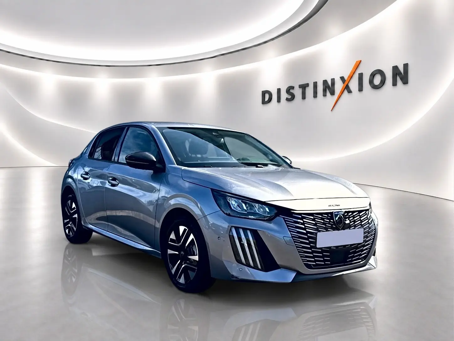 Peugeot 208 1.2 100 Allure gris Artense vue 3/4 avant droit dans un showroom lumineux.