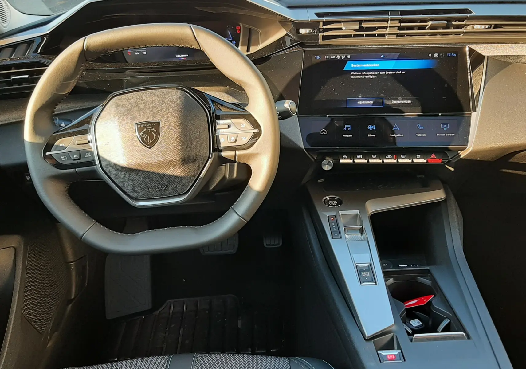 Vue intérieure du tableau de bord et volant Peugeot 308 Bleu Obsession, avec écran tactile et console centrale moderne.