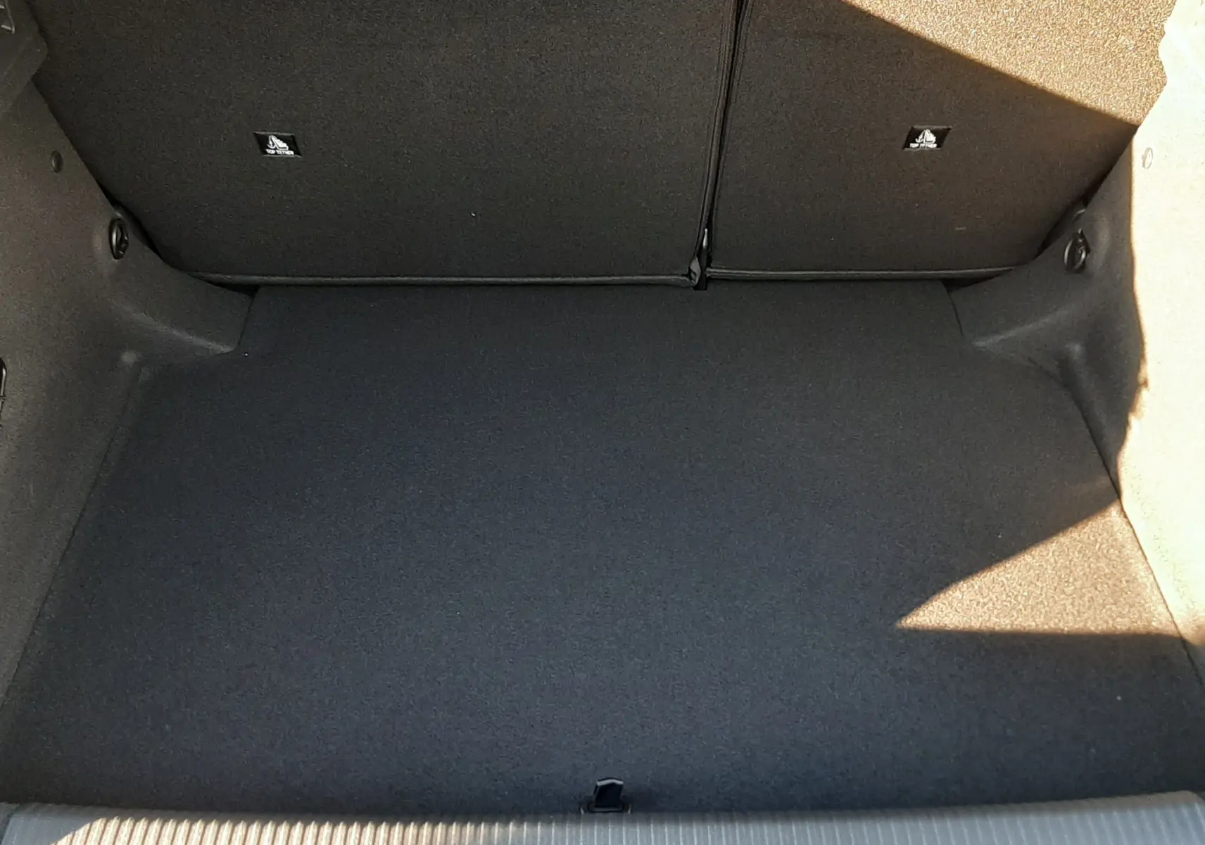 Coffre spacieux et propre de la Peugeot 308 Bleu Obsession, vue de dessus avec banquette arrière rabattue.