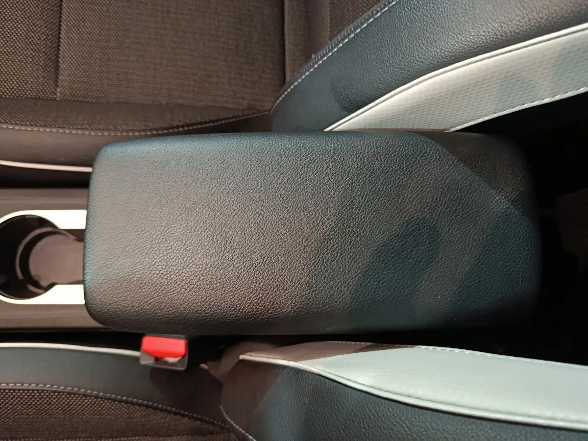 Accoudoir central noir en cuir entre les sièges avant gris et noirs du Renault Captur Techno TCe 90 2024.