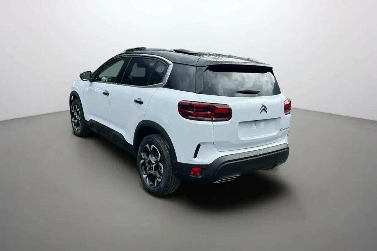 Vue 3/4 arrière droite d'un Citroën C5 Aircross blanc okénite avec toit noir et jantes alu 18 pouces.