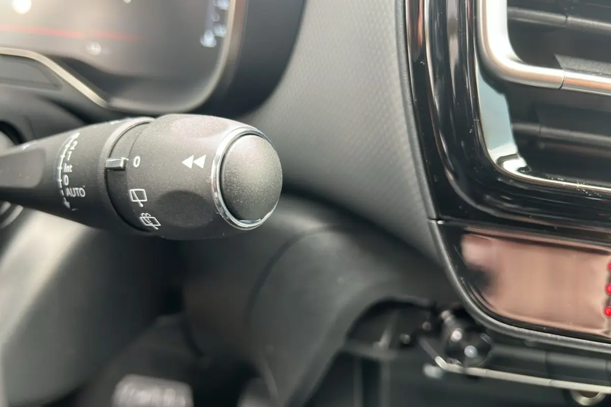 Gros plan sur la commande d’essuie-glace à gauche du volant dans l’habitacle du Citroën C5 Aircross blanc okénite.