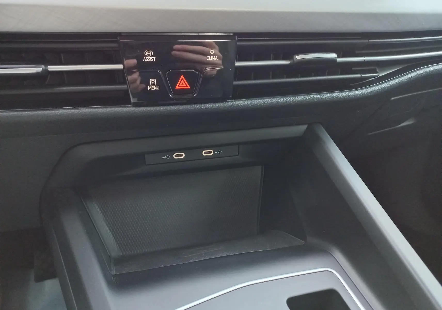 Détail de la console centrale de la Volkswagen Golf 2023, montrant les ports USB-C et les commandes d'assistance et climatisation.