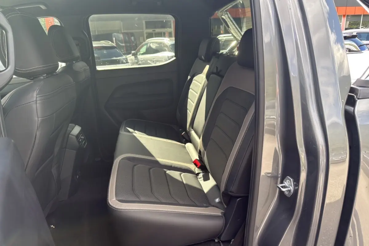 Vue intérieure côté droit montrant les sièges arrière en cuir noir du Volkswagen Amarok Simple Cabine gris foncé 2026.