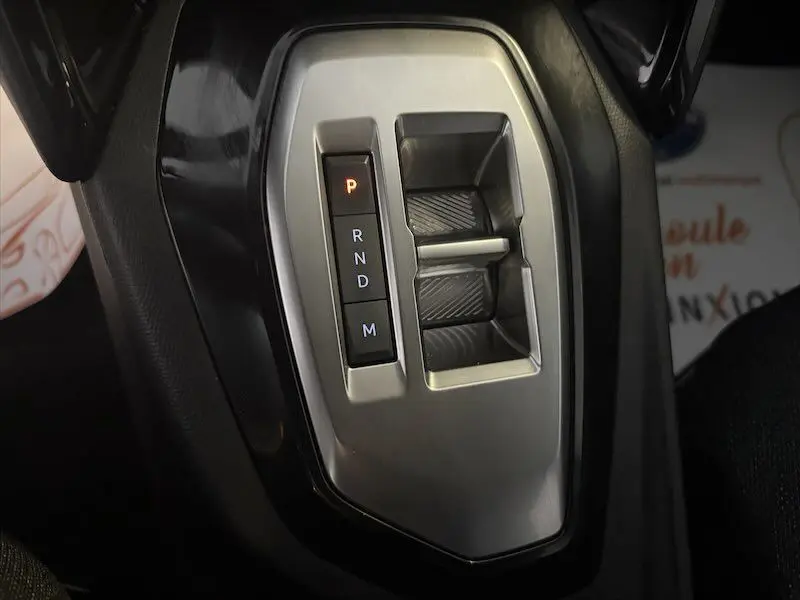 Gros plan sur la commande de boîte automatique noire et argentée du Peugeot 2008 Hybrid 145ch, mode parking activé.
