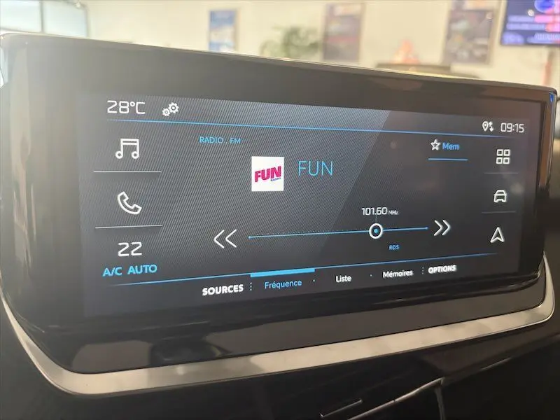 Écran tactile central du tableau de bord du Peugeot 2008 Hybrid 145ch, affichant la radio FM à 101,6 MHz.