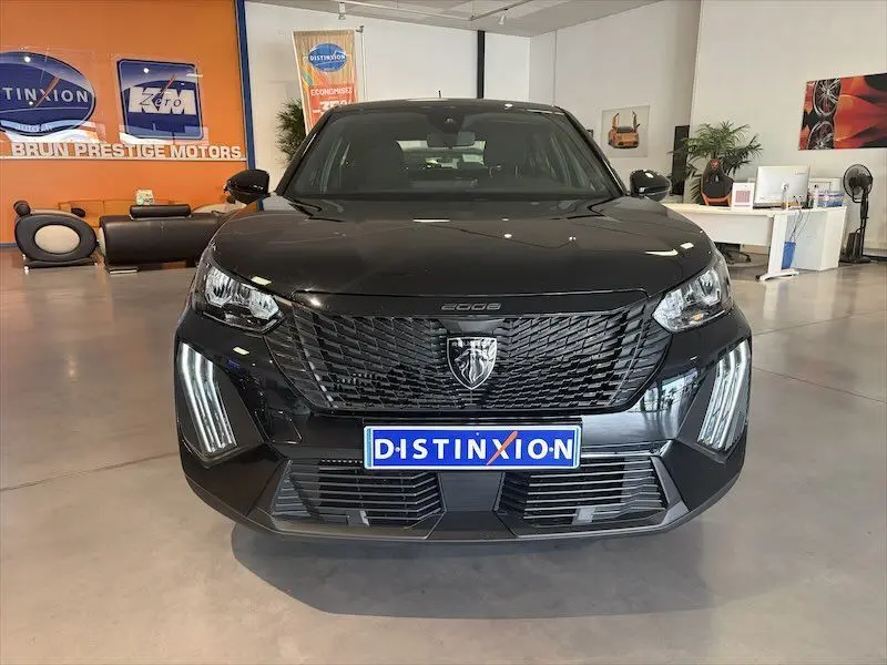 Vue de face d'un Peugeot 2008 noir métal hybride 2025, avec calandre noire et feux LED verticaux distinctifs.