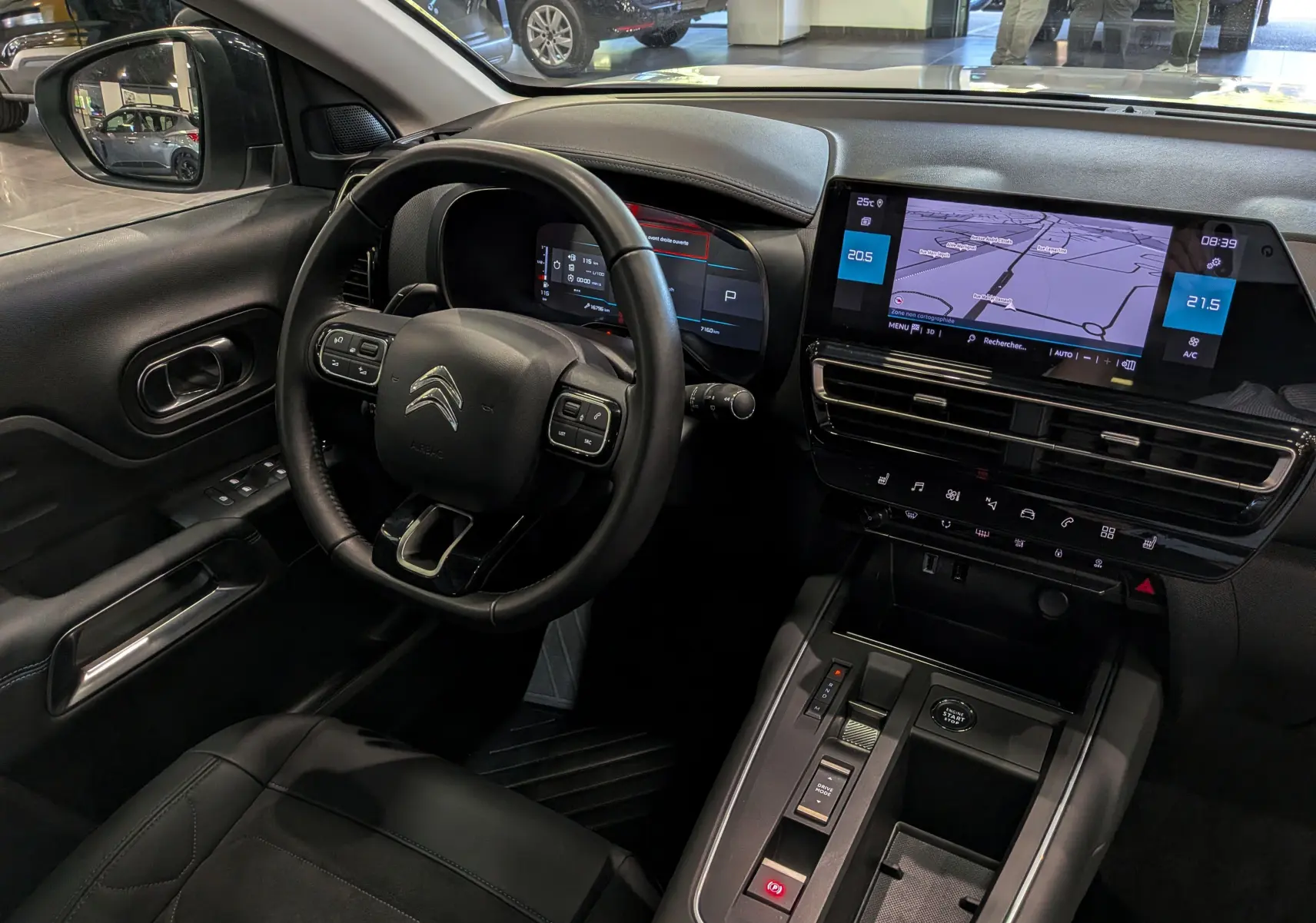 Vue intérieure côté conducteur du Citroën C5 Aircross 2025, tableau de bord avec écran tactile et volant multifonction noir.