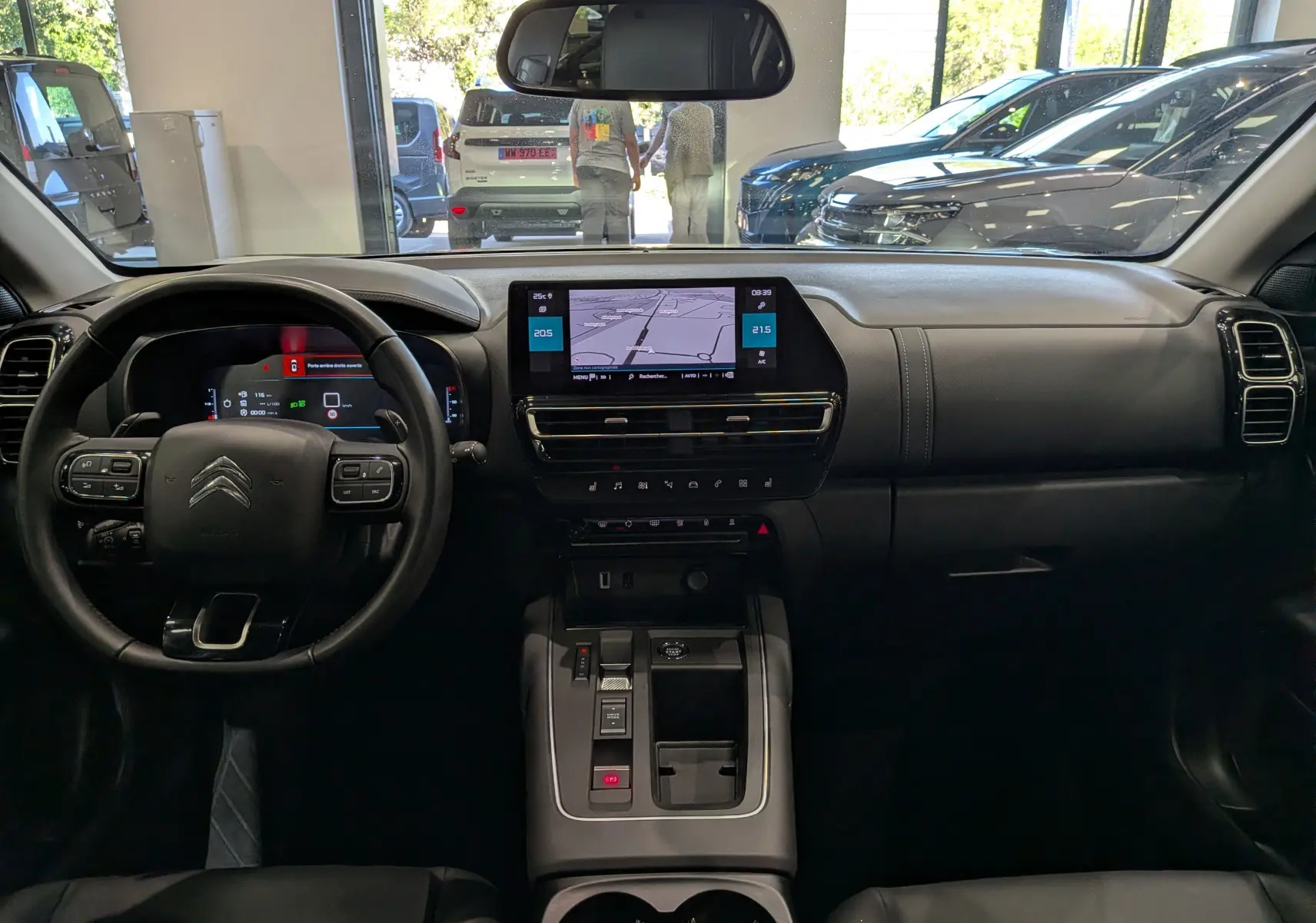 Vue intérieure frontale du tableau de bord du Citroën C5 Aircross 2025, avec écran tactile central et volant multifonction noir.