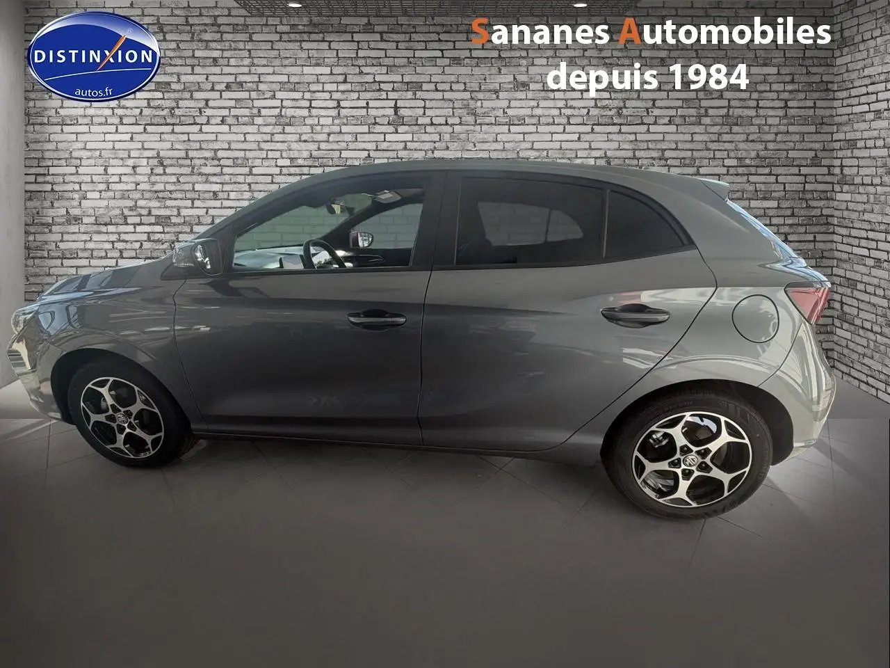 Vue de profil côté gauche d'une MG3 1.5 Hybrid+ gris Hampstead avec jantes alliage et vitres surteintées.