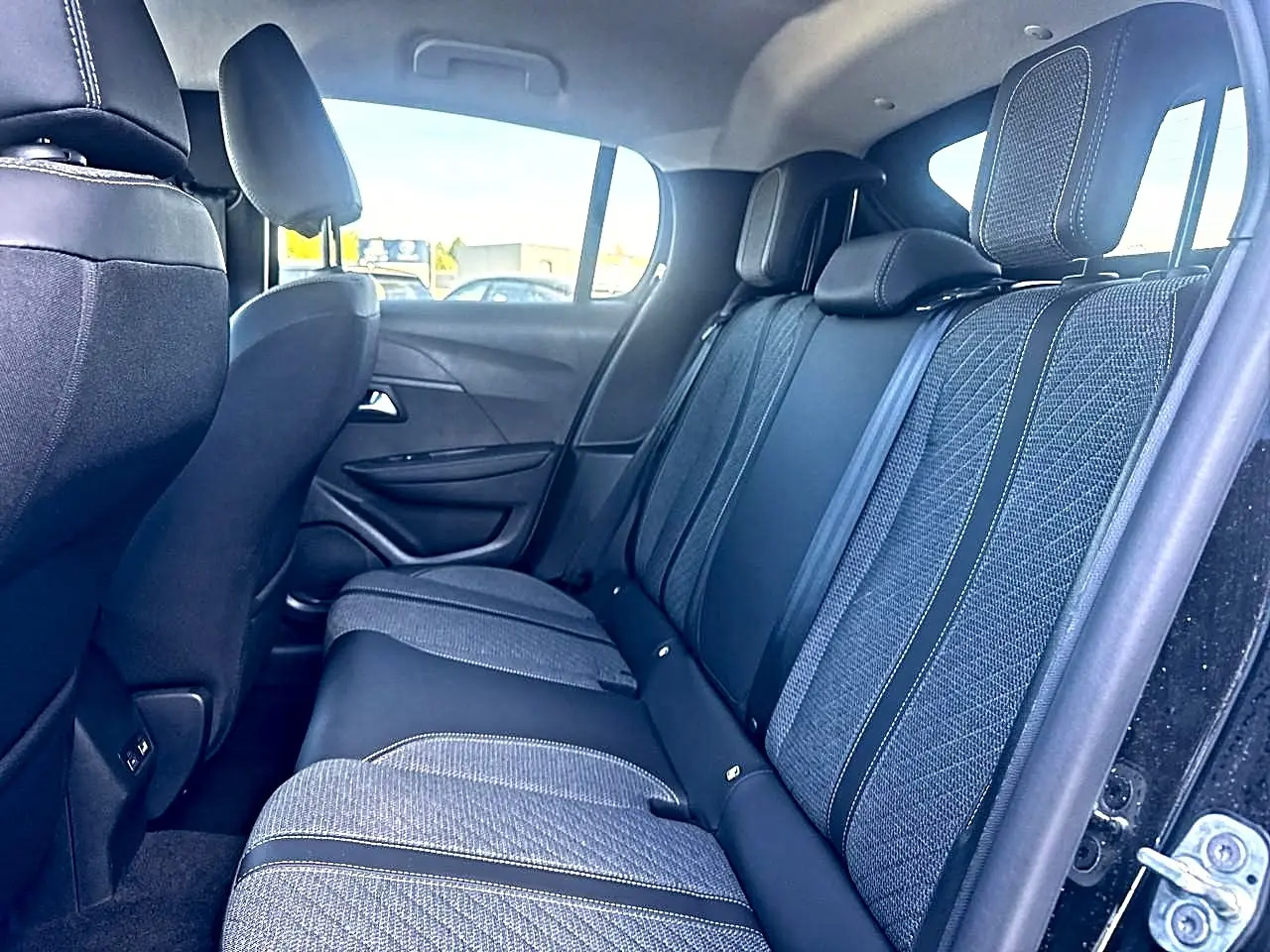 Vue latérale droite de la banquette arrière en tissu gris et noir de la Peugeot 208 1.2 100 Allure noire, 2025.