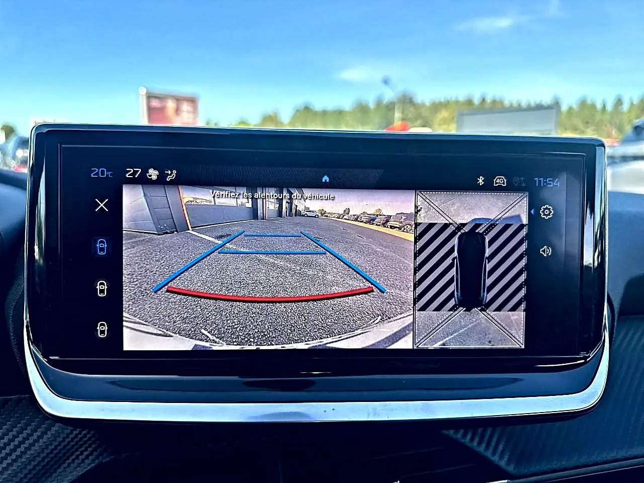 Écran tactile intérieur de Peugeot 208 noir montrant la caméra de recul et vue 360° du stationnement.