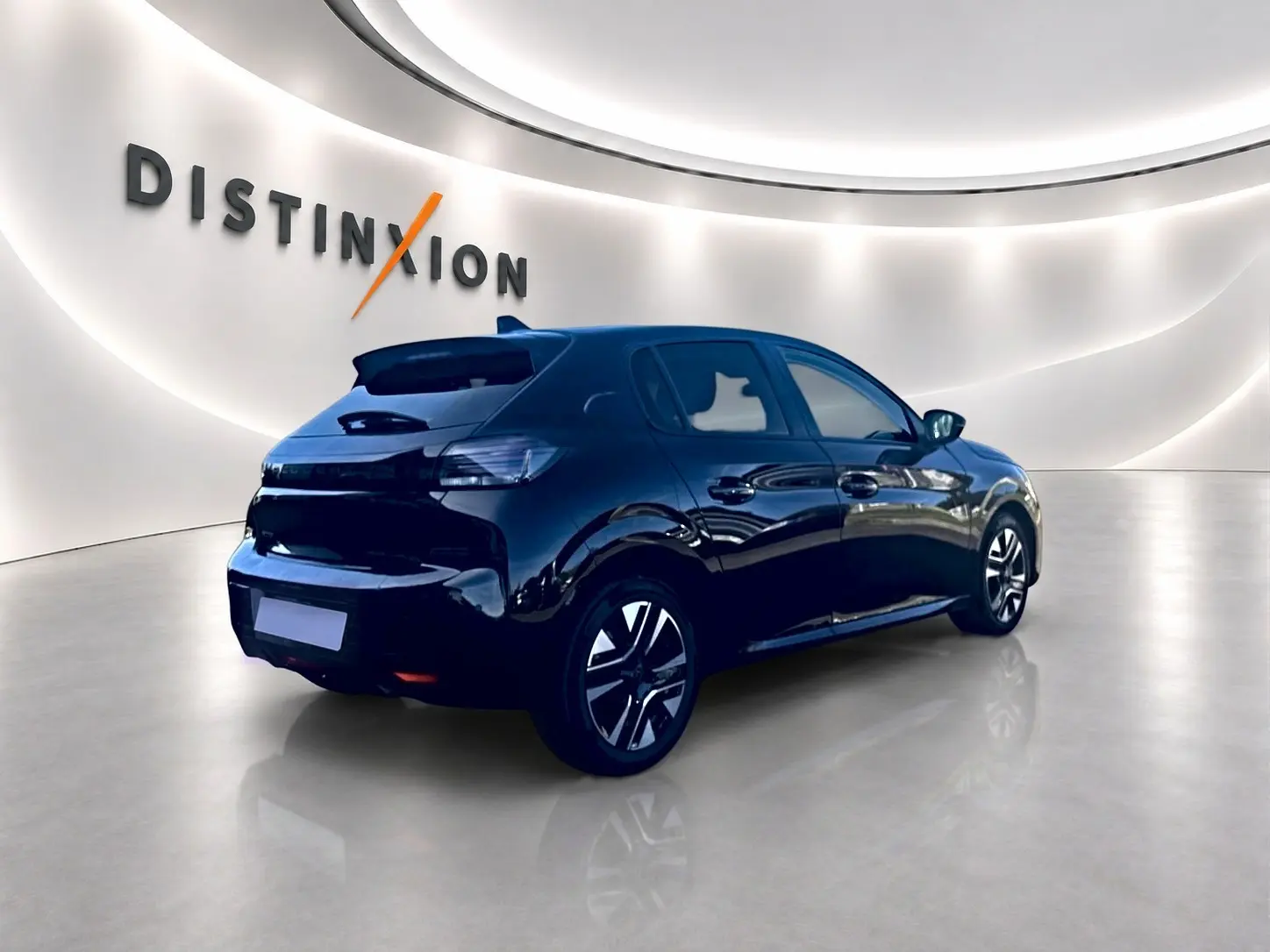 Peugeot 208 noire vue 3/4 arrière droit dans un showroom lumineux avec jantes alliage distinctives.