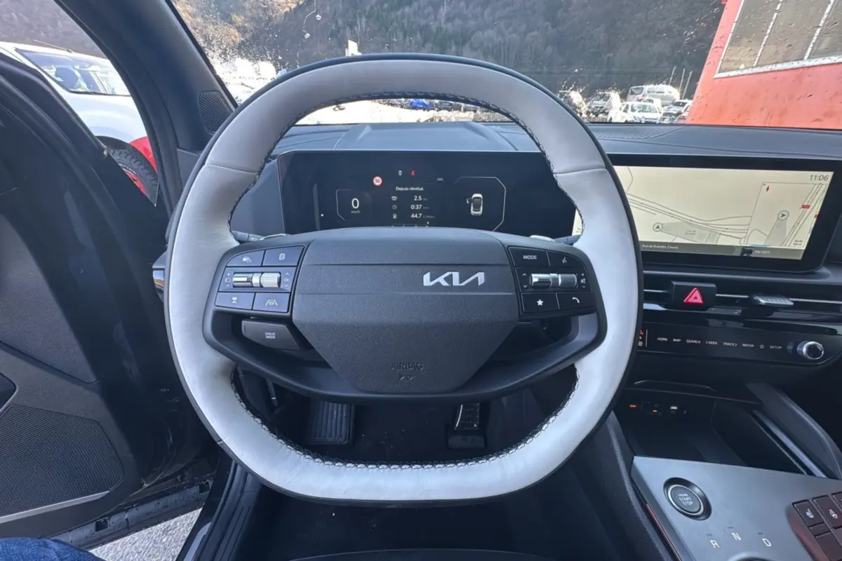 Vue intérieure centrée sur le volant cuir blanc et noir du Kia Sportage 2026 avec écran digital et GPS intégré.