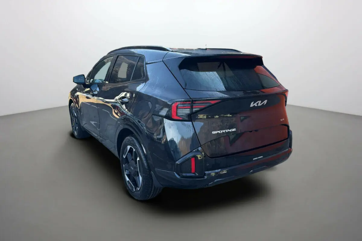 Vue 3/4 arrière droite du Kia Sportage 2026 vert bornéo avec toit noir et feux arrière LED distinctifs.