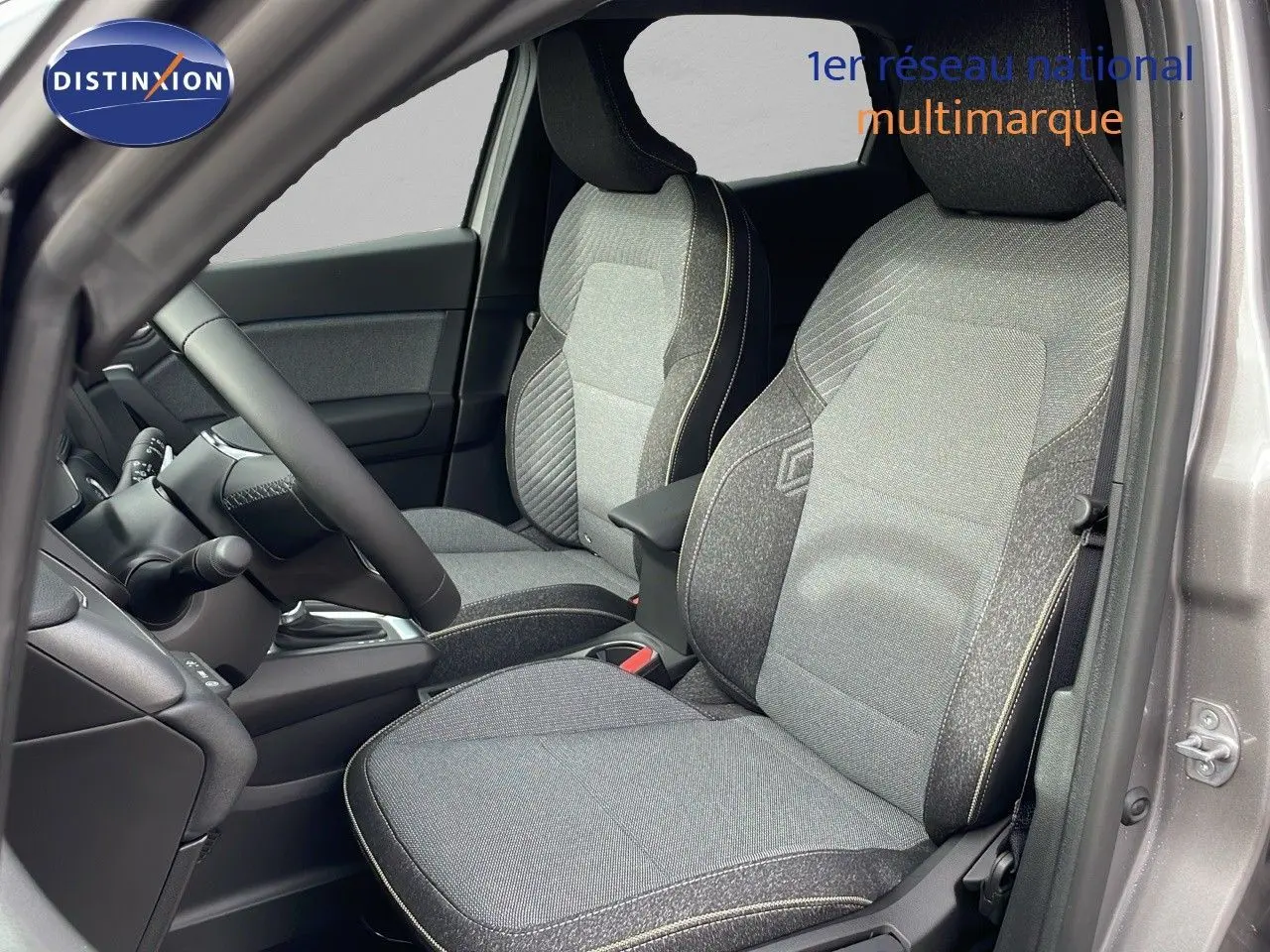 Vue intérieure côté conducteur du Renault Captur 2025 gris Cassiopée avec sièges tissu gris et détails noirs.