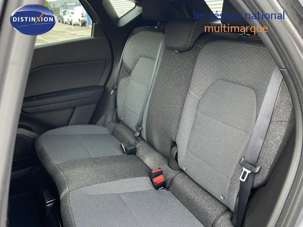 Vue intérieure du siège arrière droit du Renault Captur 2025 en tissu gris, avec ceinture de sécurité attachée.