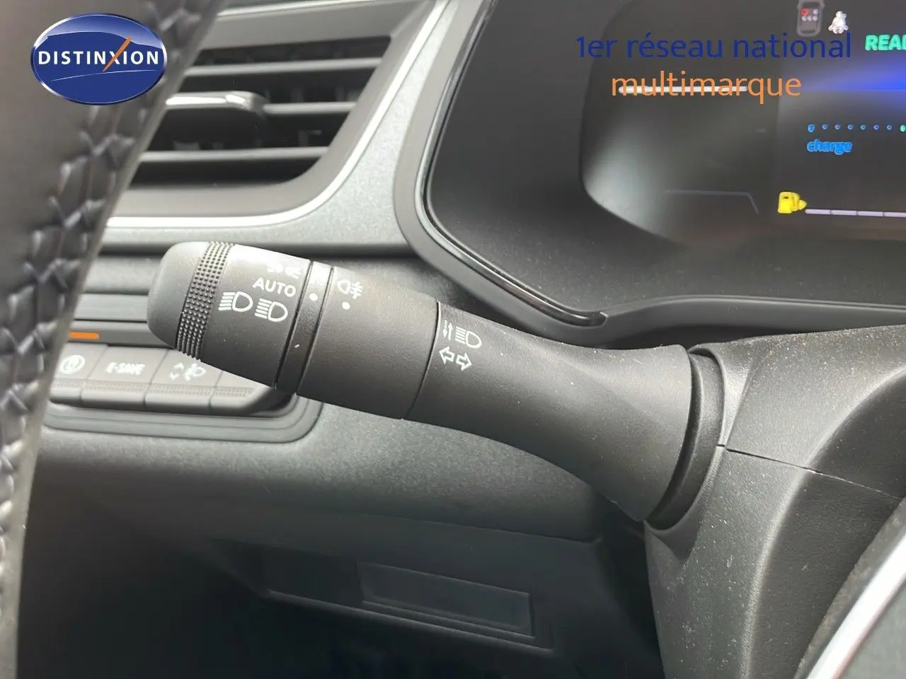 Gros plan sur la commande des feux et clignotants à gauche du volant dans l'habitacle du Renault Captur gris cassiopée.