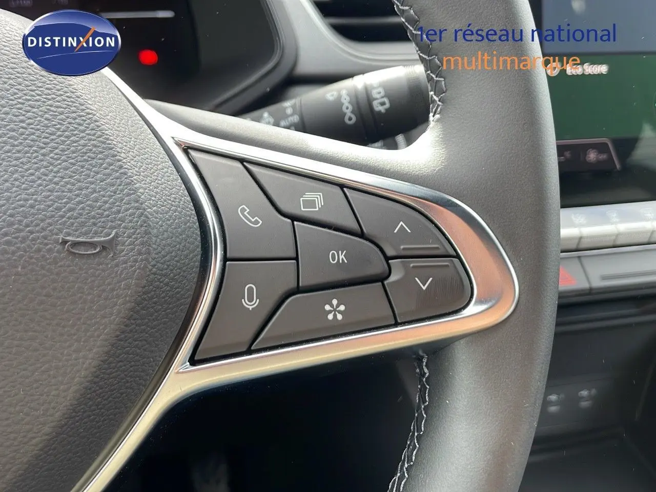 Gros plan sur les commandes du volant du Renault Captur gris cassiopée métal avec toit noir, version hybride 2025.
