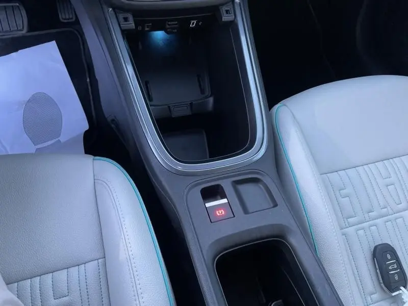 Vue rapprochée de la console centrale et des sièges blancs avec surpiqûres bleues du Fiat 600 1.2 Hybrid 2025.