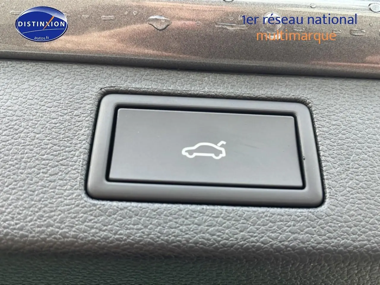 Bouton d'ouverture électrique du hayon sur tableau de bord en plastique gris d'une Skoda Kamiq 2026.