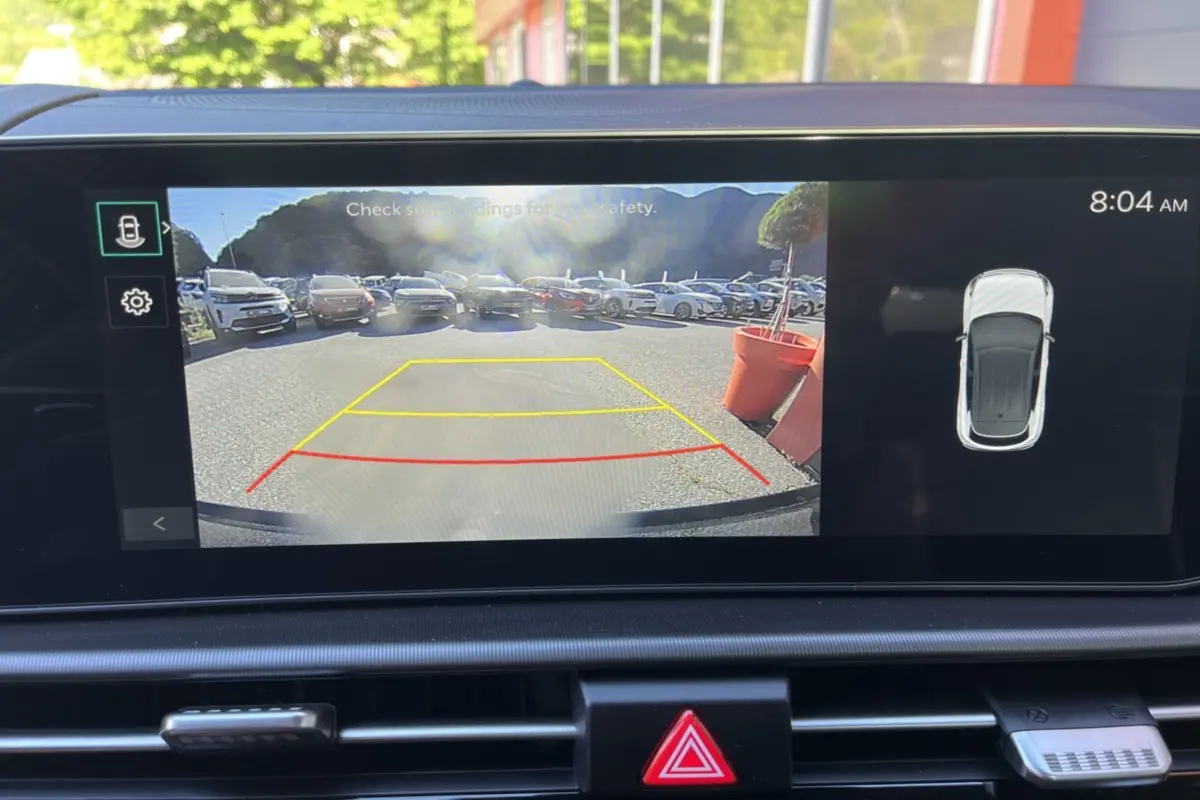 Affichage caméra de recul avec vue arrière sur parking, tableau de bord du Kia Sportage gris céramique toit noir.