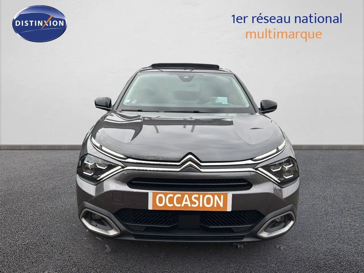 Vue frontale d'une Citroën C4 2021 gris avec toit noir et toit ouvrant, affichant une plaque "OCCASION" orange.