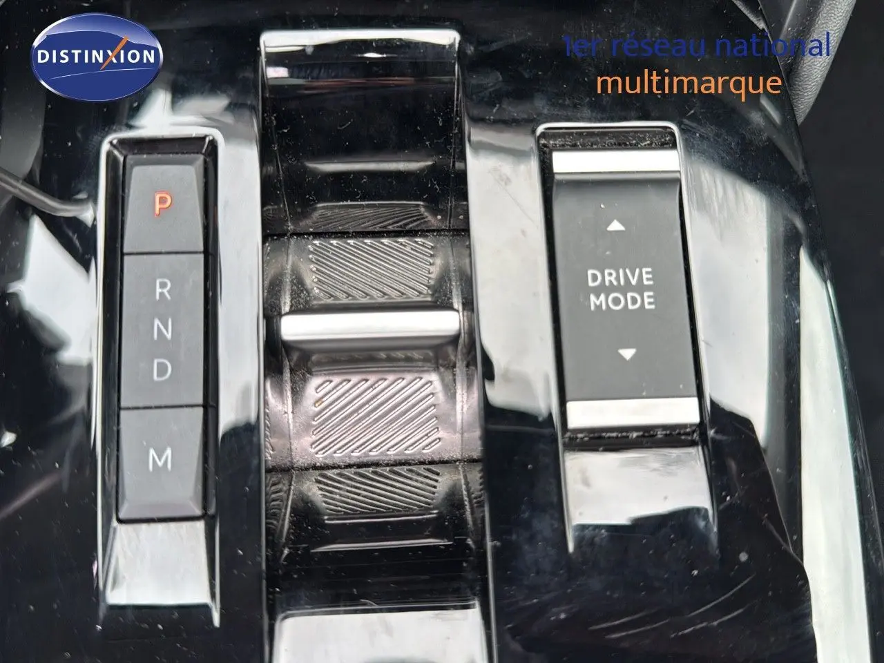 Gros plan sur la console centrale noire brillante avec sélecteur de vitesses automatique et bouton Drive Mode du Citroën C4.