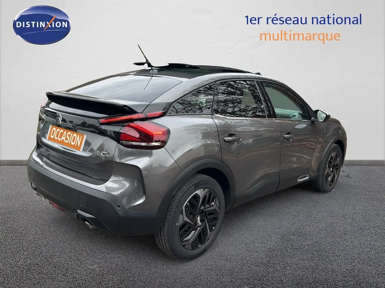 Vue 3/4 arrière droite d'une Citroën C4 2021 gris avec toit noir et jantes noires biton, toit ouvrant visible.