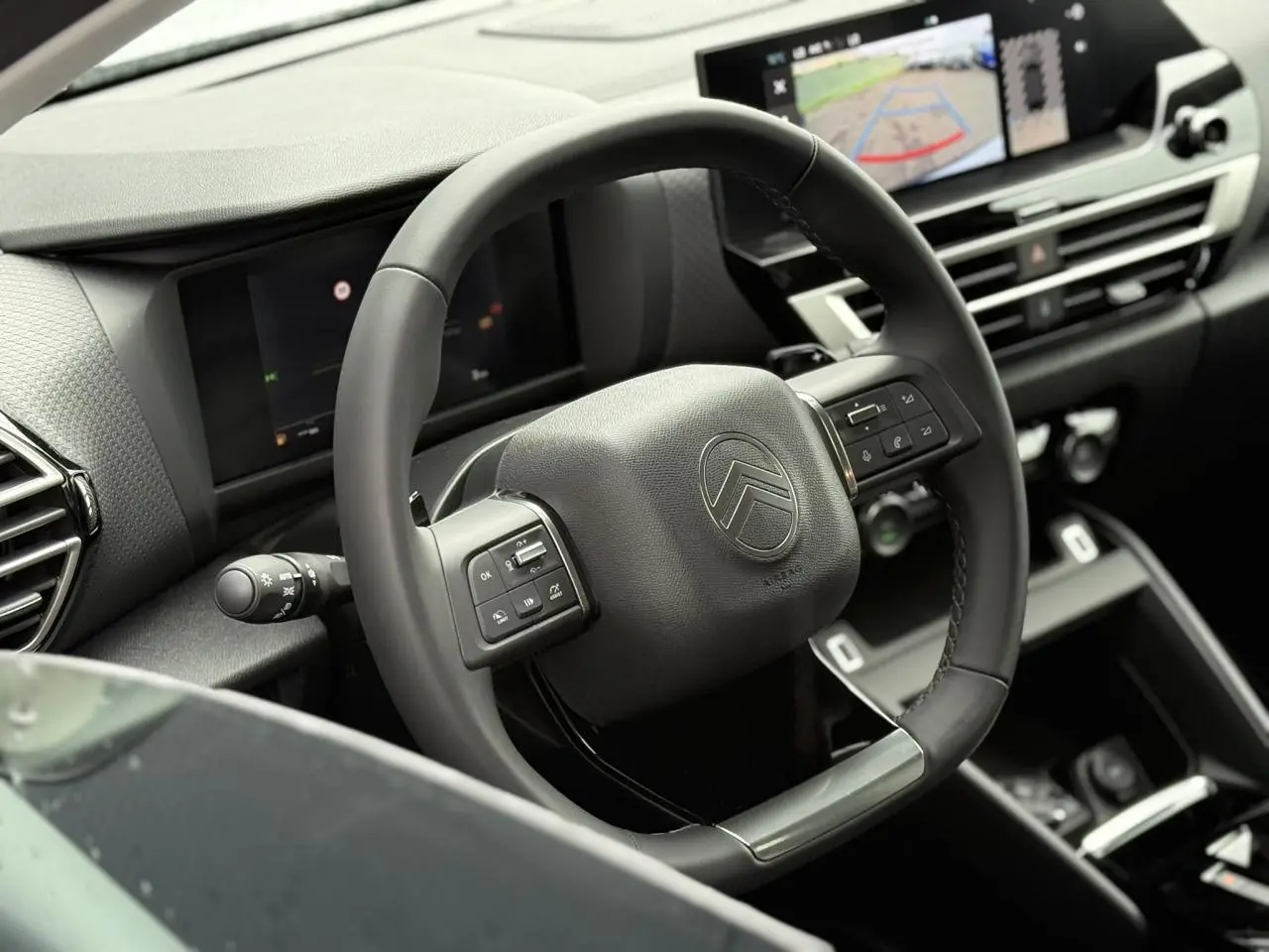 Volant cuir noir de Citroën C4 NV Hybrid 2025 avec commandes intégrées et écran tactile affichant la caméra de recul