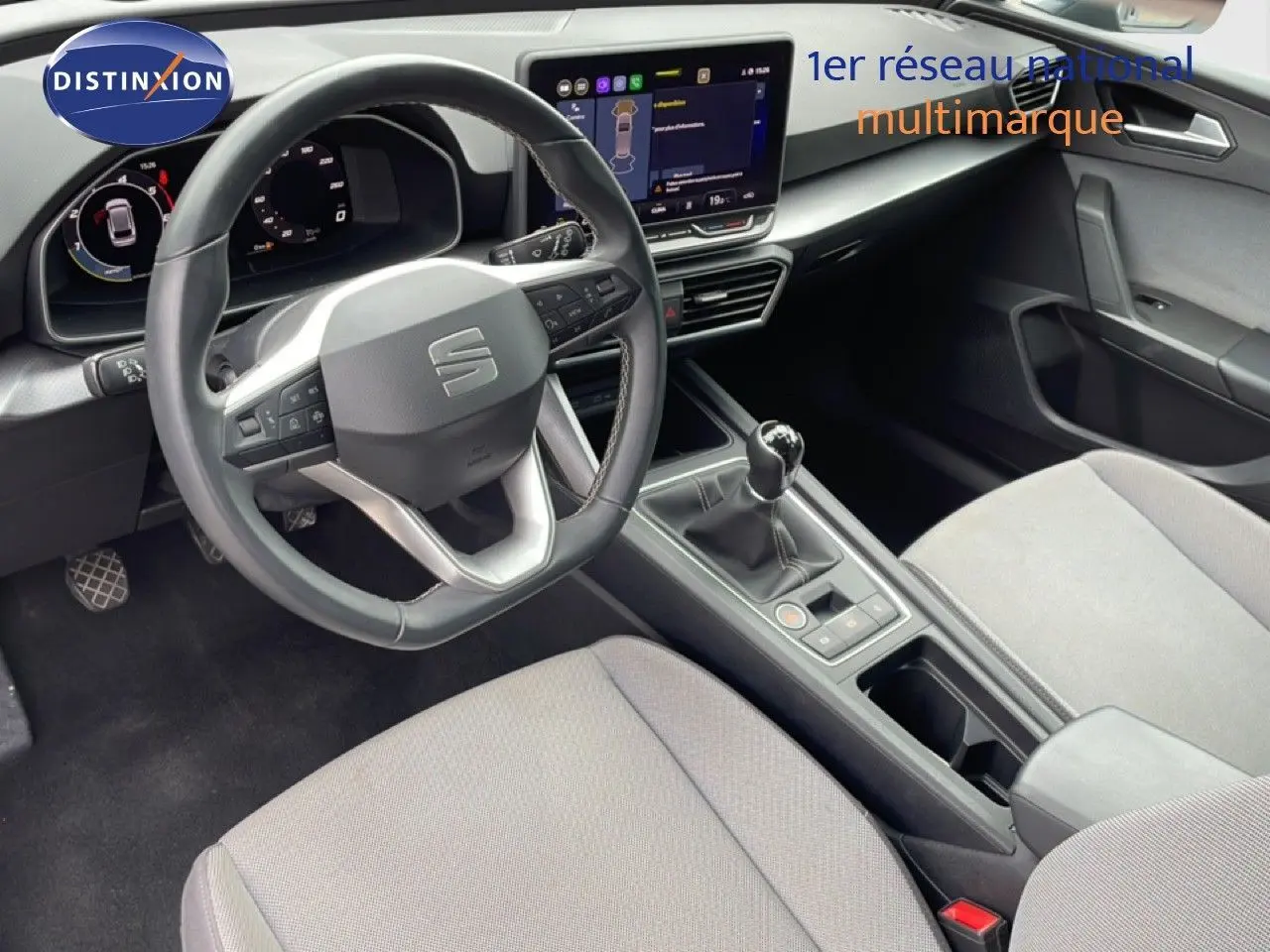 Vue intérieure côté conducteur du SEAT LEON ST 2025 gris, volant cuir multifonction et boîte manuelle visible.