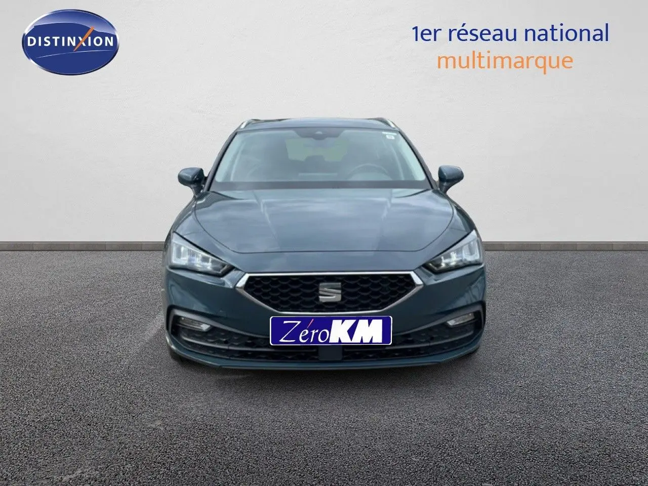 Vue frontale d'une SEAT LEON ST 2.0 TDI 115CH STYLE XL en gris magnétique métal, avec calandre hexagonale et phares LED.