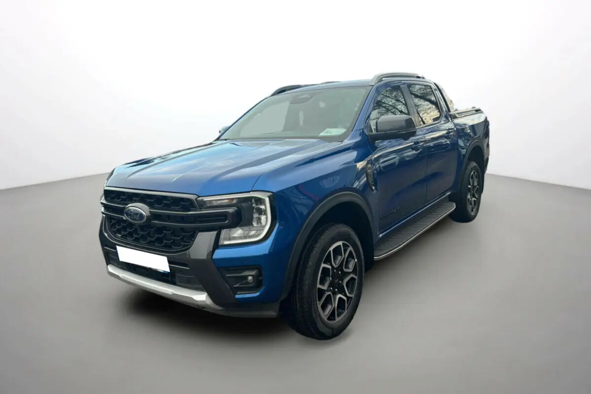 Ford Ranger 2.0 205 Wildtrak Plus bleu lightning en 3/4 avant droit avec jantes alu 20 pouces et marchepieds visibles.