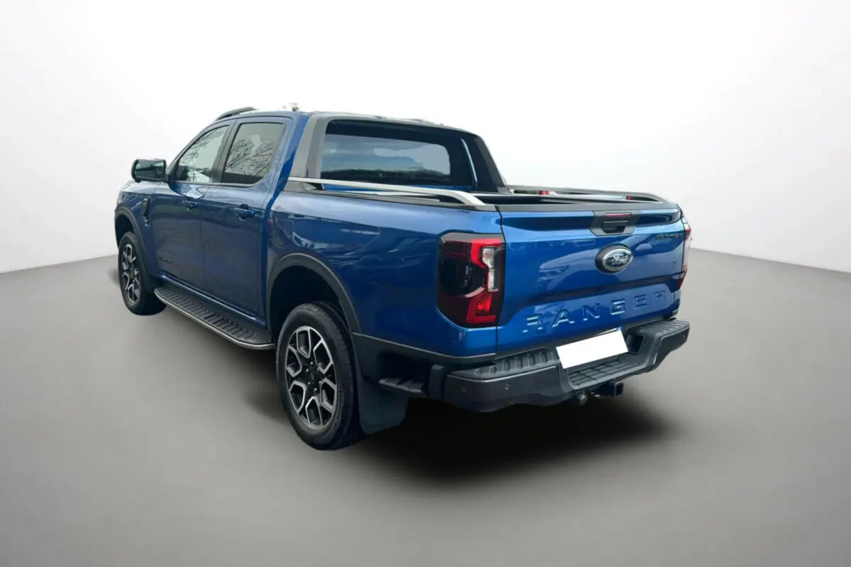 Ford Ranger 2.0 205 Wildtrak Plus bleu lightning vu en 3/4 arrière droit avec arceau sport et barres de toit.