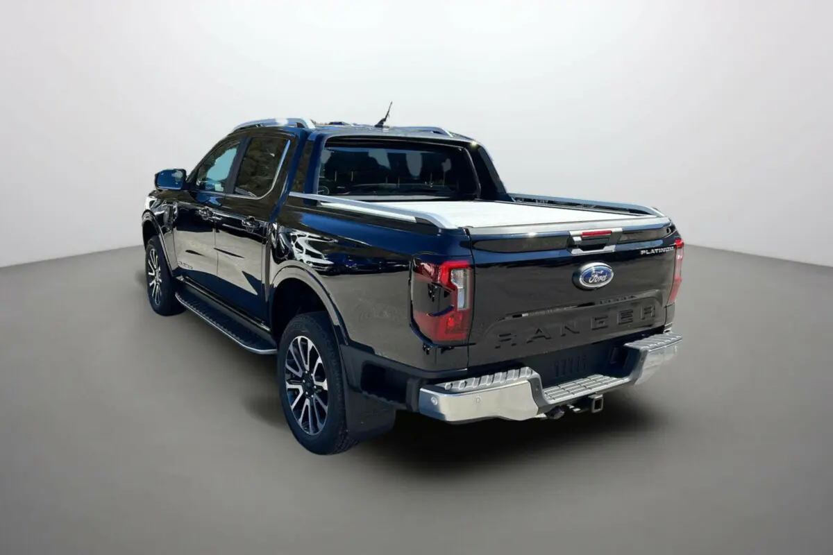 Ford Ranger 3/4 arrière droit noir agate avec benne couverte et jantes alu 20 pouces visibles.