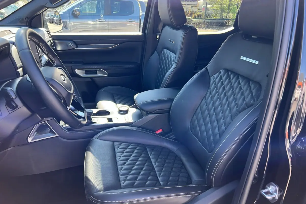Vue intérieure côté gauche du Ford Ranger 3.0 V6 Platinum avec sièges cuir noirs matelassés et logo Platinum.
