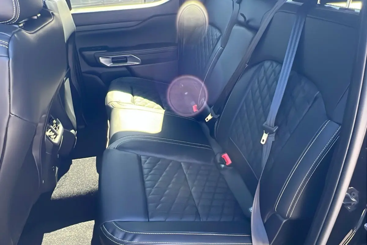 Vue intérieure arrière côté droit du Ford Ranger 2026 noir agate, sièges cuir noir matelassé avec surpiqûres blanches.