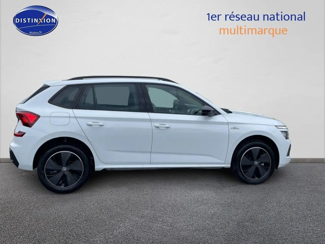 Profil droit d'un Skoda Kamiq blanc nacré 2026 avec jantes noires et toit panoramique en verre.