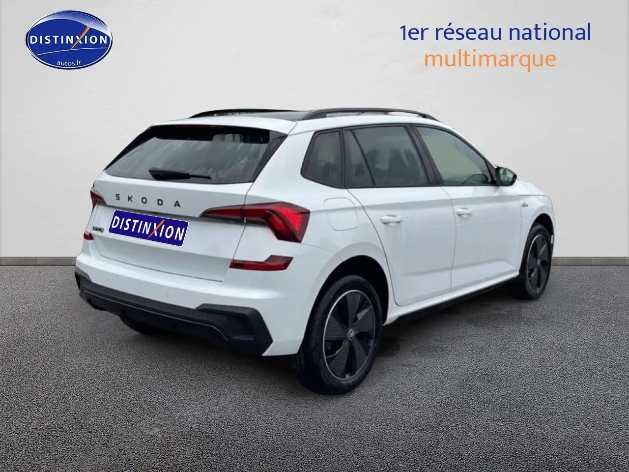 Vue 3/4 arrière droite d'un Skoda Kamiq blanc nacré avec jantes noires et toit panoramique en verre.
