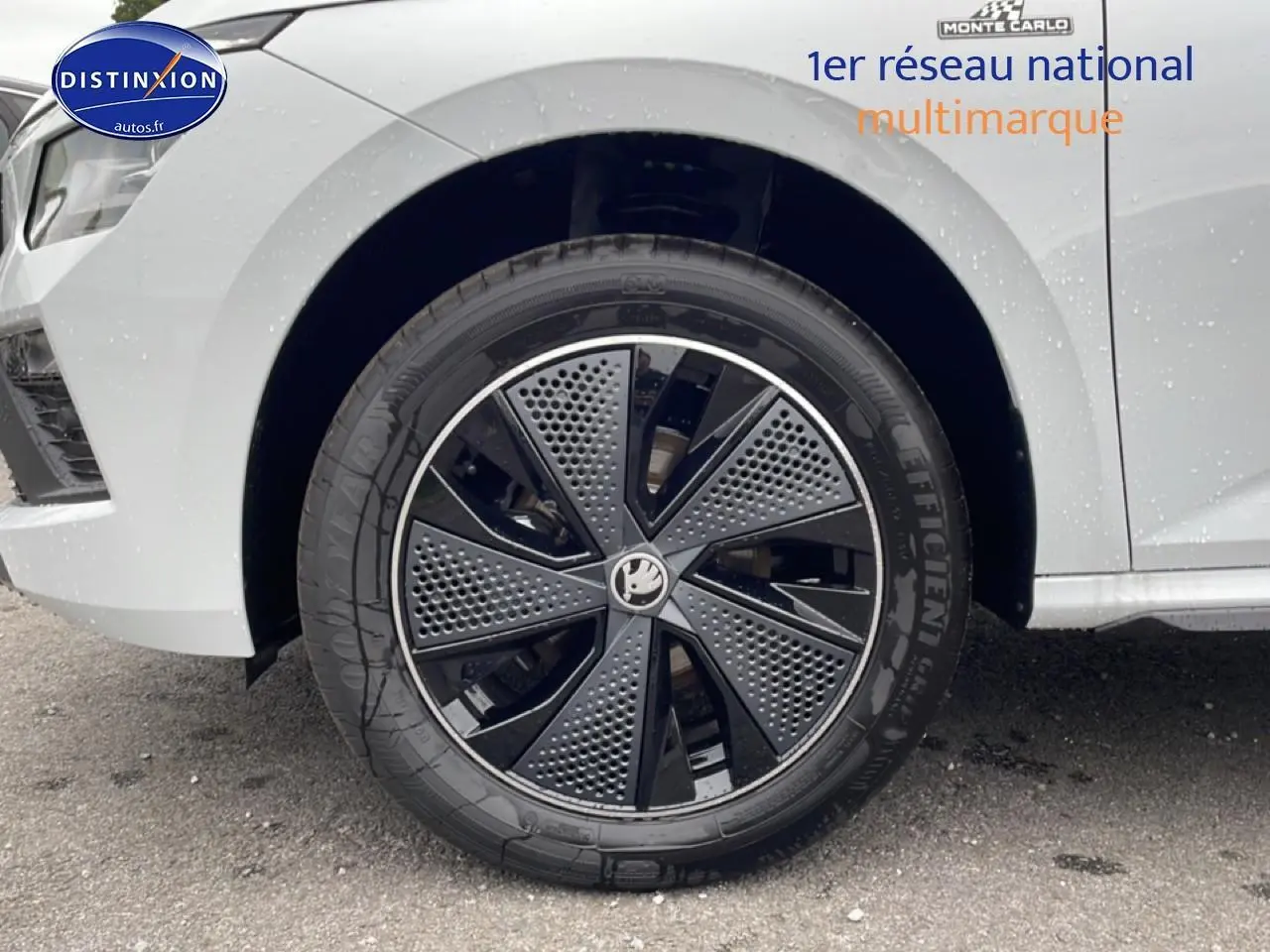 Gros plan sur la roue avant droite du Skoda Kamiq blanc nacré avec jante alu noire et grise au design moderne.