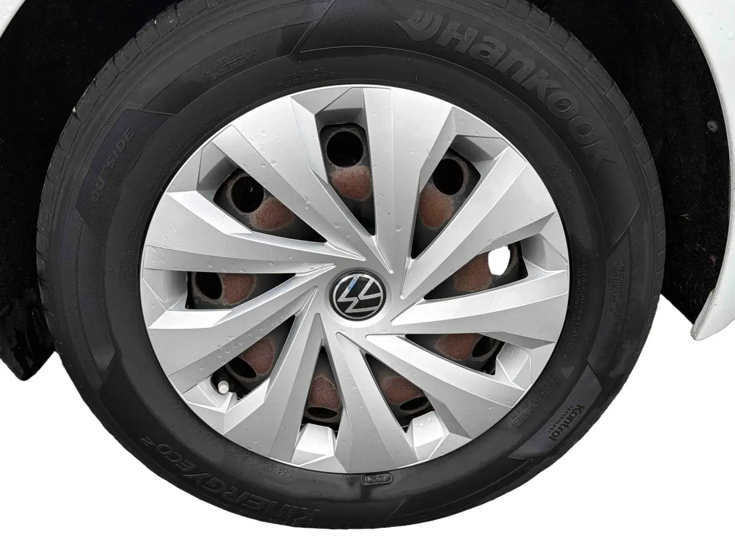 Gros plan sur la roue avant droite d'une Volkswagen Polo Business blanche avec enjoliveur argenté et pneu Hankook.