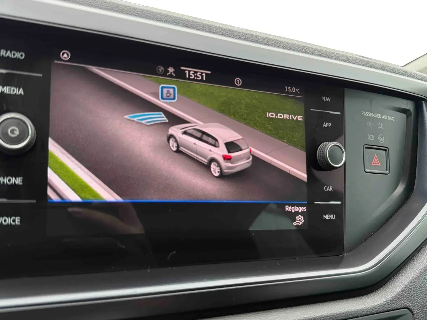 Écran de navigation affichant une voiture blanche vue en 3/4 arrière sur une route virtuelle.