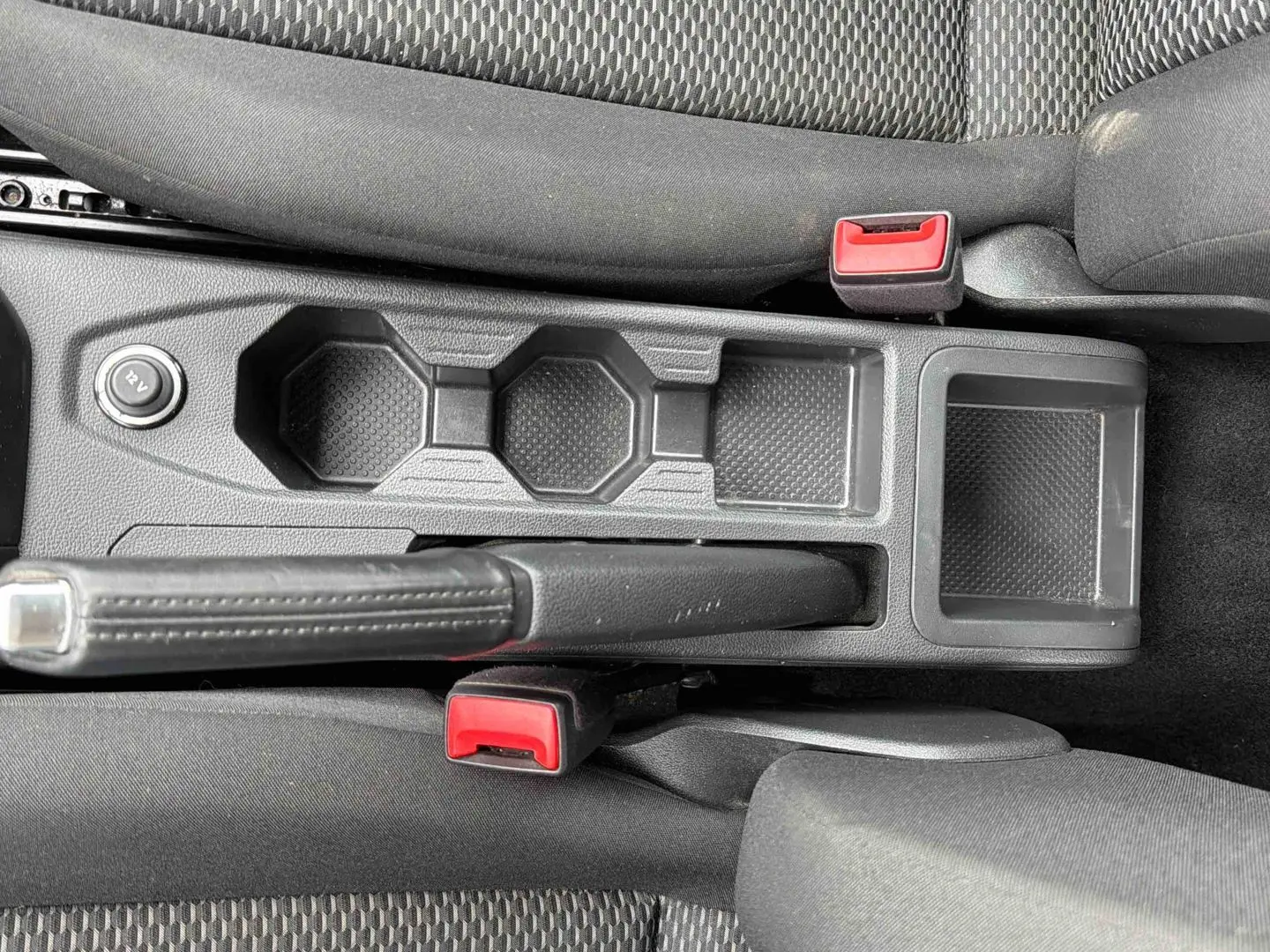 Vue plongeante sur la console centrale noire avec frein à main et prises 12V de la Volkswagen Polo Business 2021.