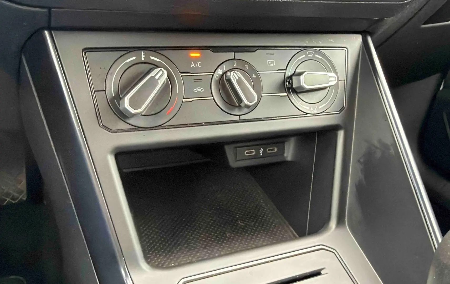 Vue rapprochée de la console centrale de la Volkswagen Polo Business 2021, montrant les commandes de climatisation manuelle et ports USB.